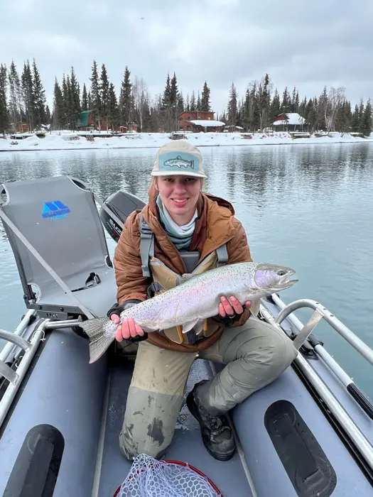 Angler holding a rainbow trout in a raft